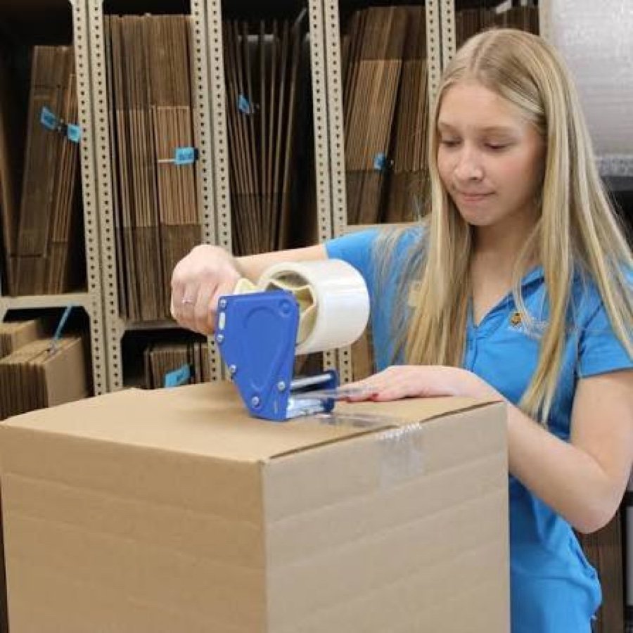 Store staff opening a freshly delivered pallet of brand-name stock